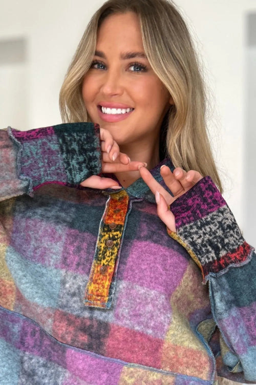 Woman wearing a colorful patchwork sweater with a blurred background