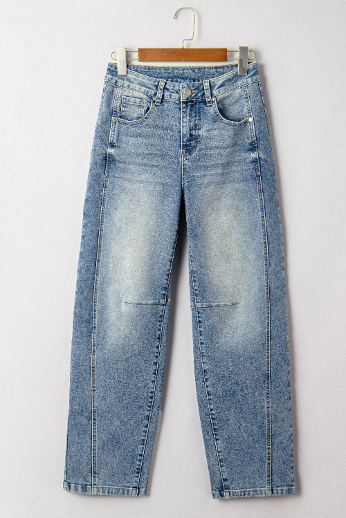 Light blue jeans on a wooden hanger against a white background