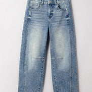 Light blue jeans on a wooden hanger against a white background