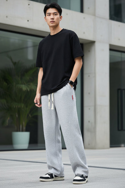 Person wearing gray sweatpants with a white background