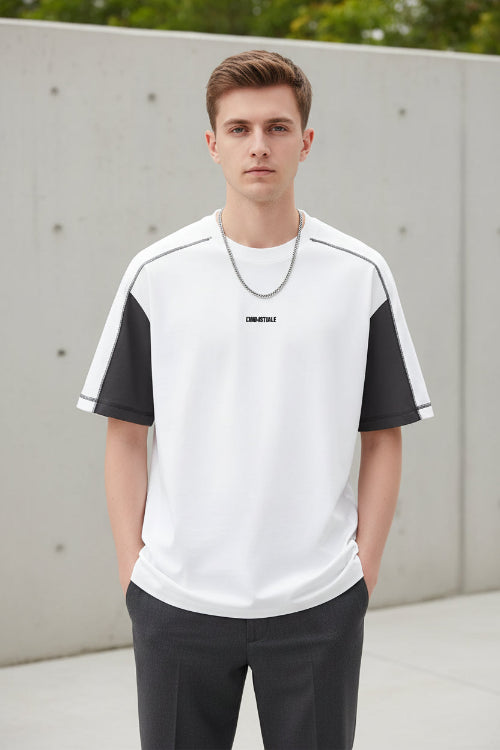 Person wearing a white t-shirt with black accents on a plain background