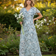 Woman wearing a floral dress holding flowers on a white background