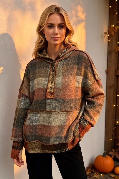A woman wearing a distressed, multi-colored plaid pullover hoodie with a front button placket and drawstring hood, 