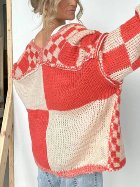 Red and white checkered sweater worn by a person on a plain background