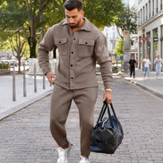 A man wearing a matching taupe-brown fleece jacket and jogger pants set,