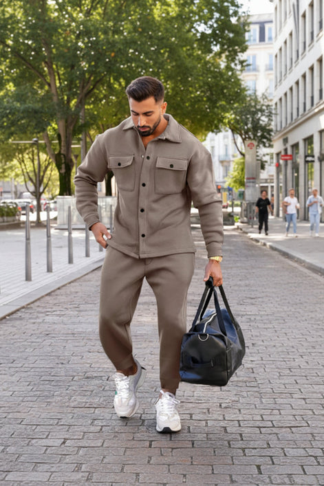 A man wearing a matching taupe-brown fleece jacket and jogger pants set,