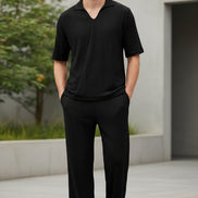 Black polo shirt and black pants on a white background