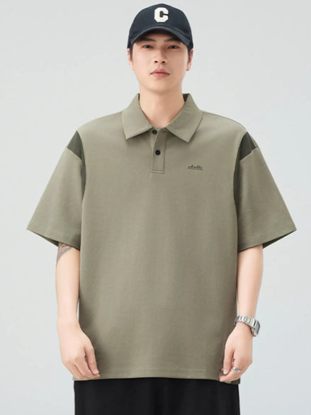 Person wearing a green polo shirt with black accents on a gray background