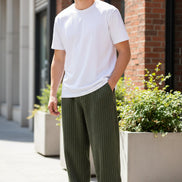 Green corduroy pants worn by a person on a white background