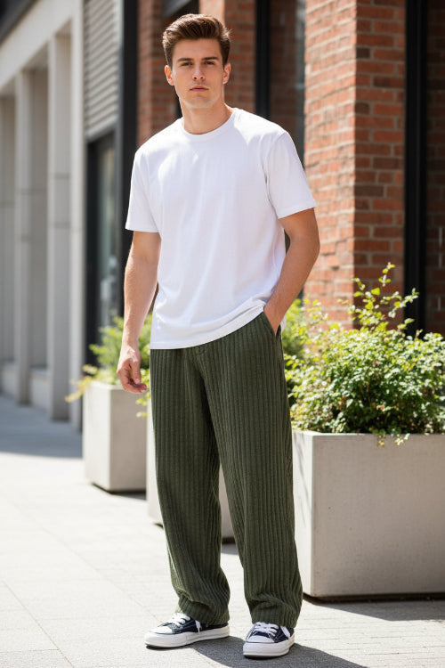 Green corduroy pants worn by a person on a white background