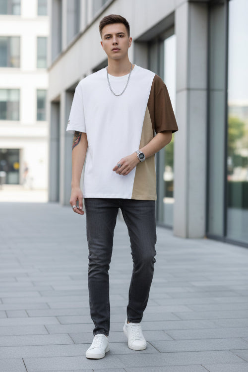 Person wearing a white and brown color-blocked t-shirt on a plain background