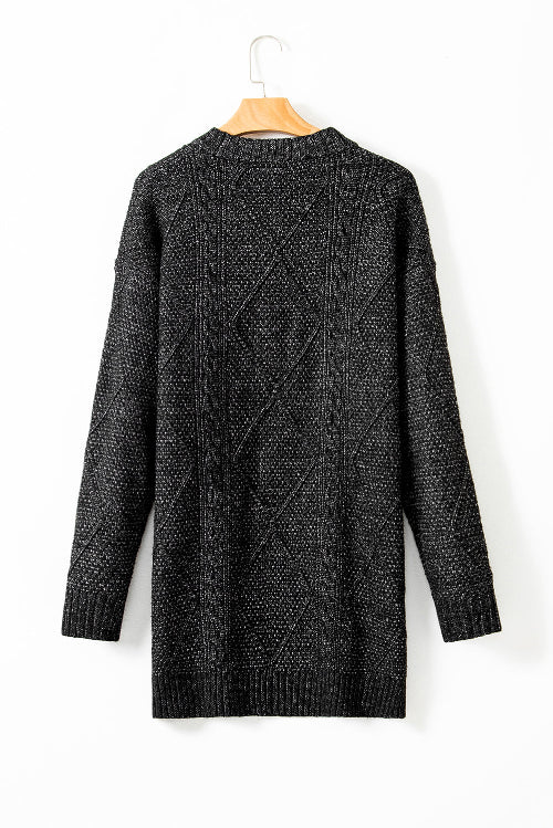 Black knitted cardigan on a hanger against a white background