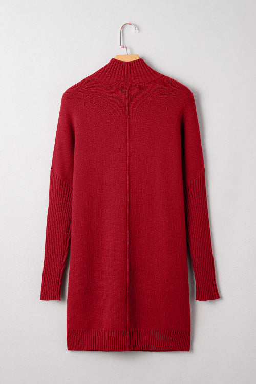 Red sweater dress on a hanger against a light gray background