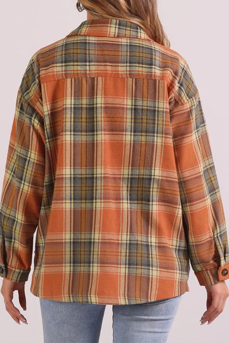 Plaid shirt with orange and green pattern worn by a person on a white background