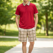 Red polo shirt with plaid collar and beige plaid shorts on a white background
