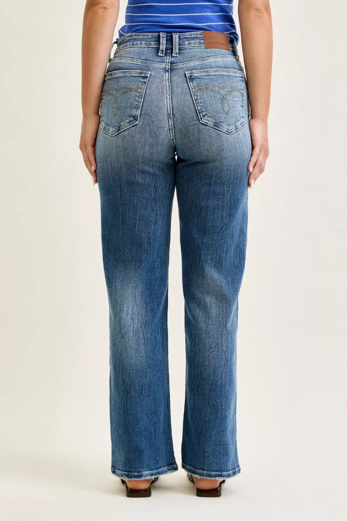 Person wearing blue jeans on a plain background