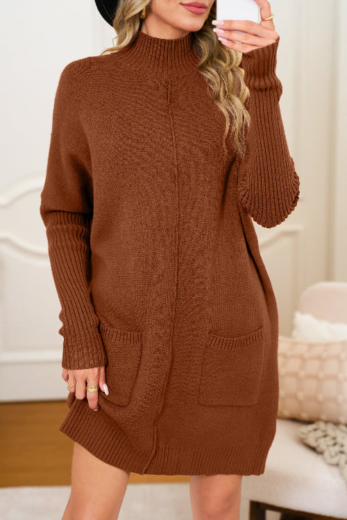 Woman wearing a brown knitted dress with pockets indoors.
