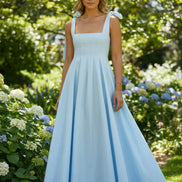 Light blue dress with ribbon straps worn by a person on a white background