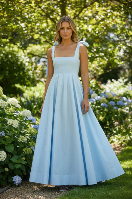 Light blue dress with ribbon straps worn by a person on a white background