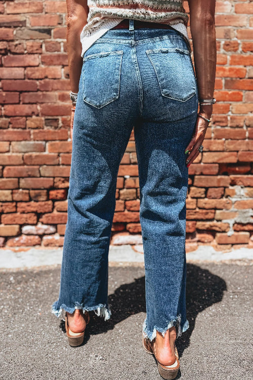 Person wearing blue jeans with a brick wall background