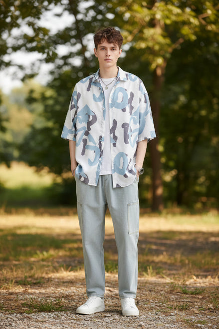 Person wearing a patterned shirt with abstract designs on a white background