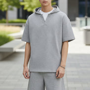 Person wearing a gray outfit with a plain background