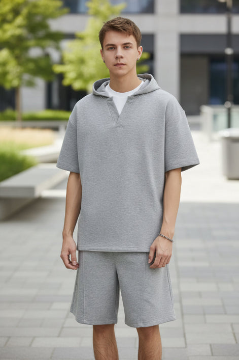 Person wearing a gray outfit with a plain background