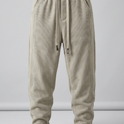 Beige baggy sweatpants with a drawstring waist and cuffed ankles, shown against a plain studio background.
