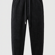 Black baggy sweatpants with a drawstring waist and cuffed ankles, shown against a plain studio background.